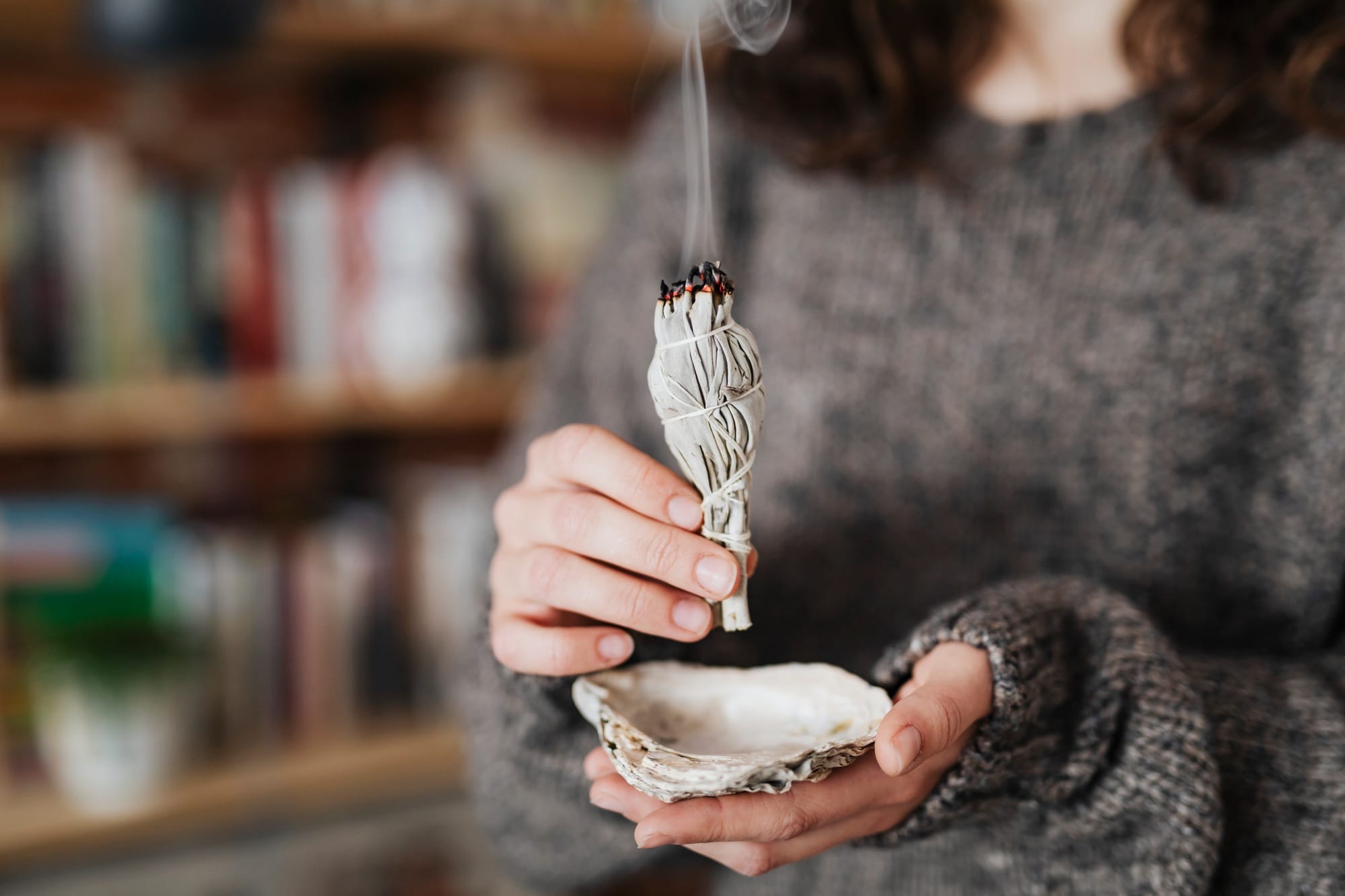 Woman burning sage smudge to cleanse the house